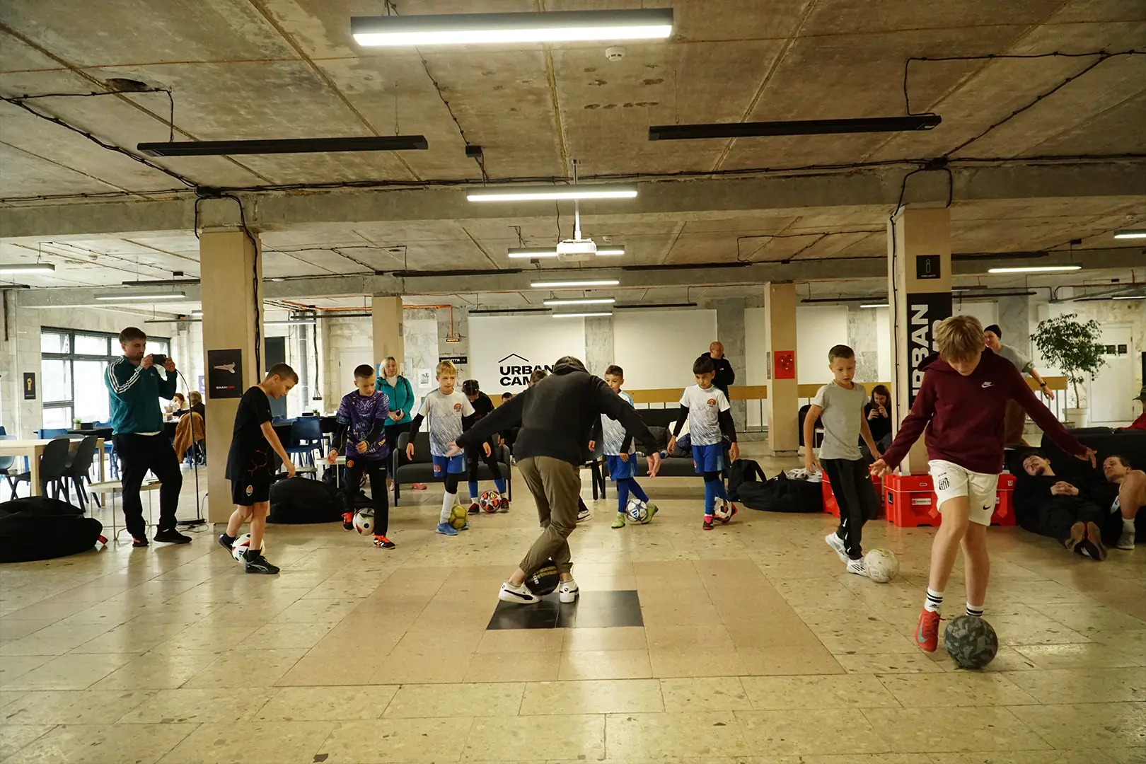 Michał Rycaj prowadzący warsztaty freestyle football dla młodzieży w budynku Urban Camp we Lwowie.